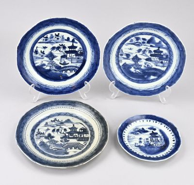 quatre assiettes bleues et blanches ornées d'un paysage