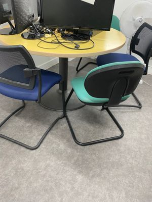 une table avec deux chaises et un ordinateur portable posé dessus