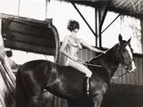 une femme assise sur un cheval dans une grange