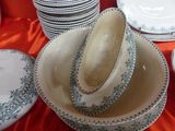 several plates and bowls are stacked on a table with a red table cloth