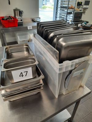 several trays of food are stacked on a table in a kitchen