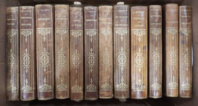 de nombreux livres anciens dans une boîte en bois posée sur une étagère