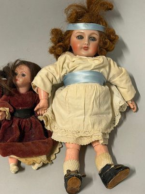 deux poupées assises l'une à côté de l'autre sur une table