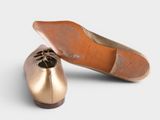 an image of a pair of gold shoes on a white surface