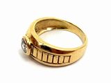 a gold ring with a diamond in it on a white surface