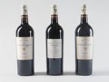 three bottles of wine are lined up on a white surface