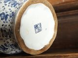 a blue and white vase sitting on top of a wooden table