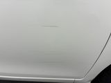 a close up of a white car with scratches on the side of it