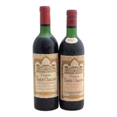 two bottles of red wine sitting next to each other on a white surface