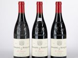 trois bouteilles de vin rouge posées sur une table blanche