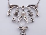 a close up of a necklace on a white surface