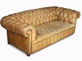 a brown leather couch that is sitting on a white surface