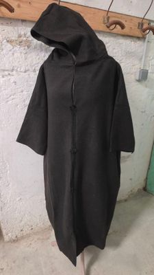 un sweat à capuche noir posé sur un mannequin dans une pièce