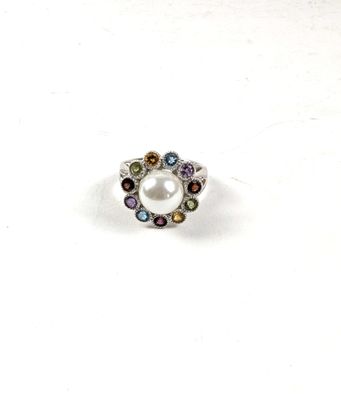 un gros plan d'une bague ornée d'une perle entourée de pierres multicolores