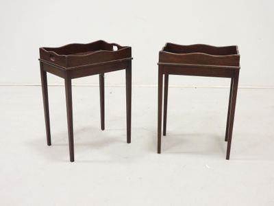 pair of small side tables with trays on each of them
