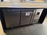 two stainless steel refrigerators sitting on top of a counter in a store