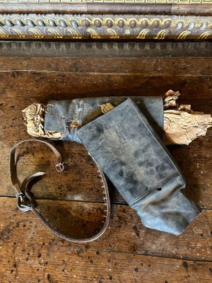 une vieille paire de chaussures et un sac posés sur un parquet