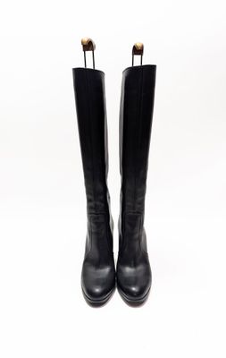 une paire de bottes en cuir noir sur fond blanc