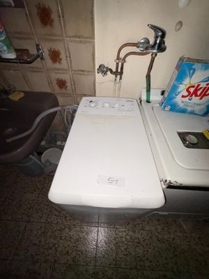 une machine à laver blanche et un sèche-linge dans une petite pièce