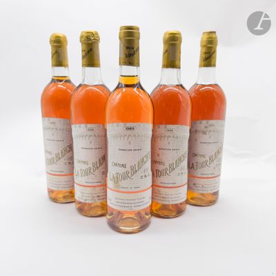 quatre bouteilles de vin sont alignées sur une surface blanche