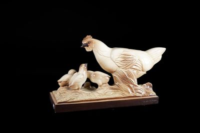 une sculpture blanche représentant un oiseau et deux oiseaux posés sur une table