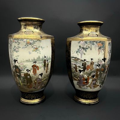 pair of asian vases with figures on them on a black background