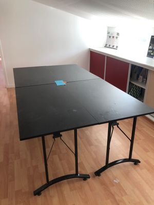 a black table with a blue sticker on it in the middle of a room