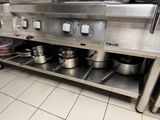 many pots and pans on the shelf in the kitchen
