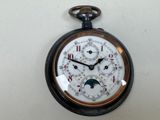 un gros plan d'une montre de poche accrochée au mur