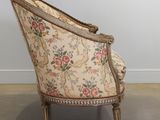 an old fashioned chair with a floral upholstered back and wooden legs