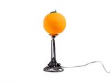 une lampe sur laquelle est posée une orange