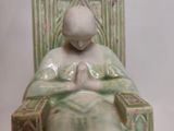 a figurine of a woman sitting in a chair