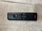 a remote control sitting on the floor next to a cell phone