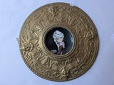 an image of a picture of a woman in a hat on a gold plate