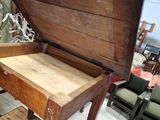 an old wooden table with a drawer on it