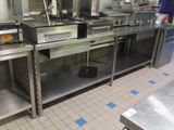 une grande cuisine avec de nombreux plans de travail en inox