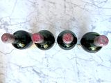 three bottles of wine are lined up on a marble table