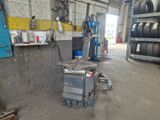 une machine qui se trouve dans un garage, à côté de quelques pneus