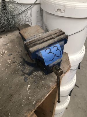 a clamp sitting on top of a table next to a bucket