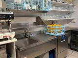 a kitchen with a sink, stove, dishwasher, and refrigerator