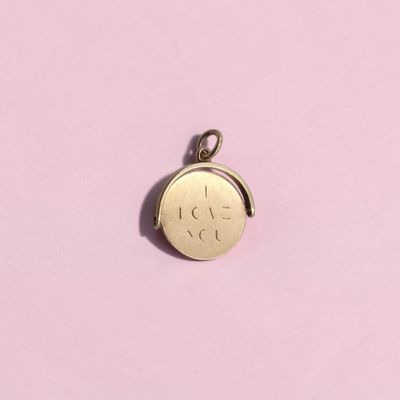 un gros plan d'une pièce d'or posée sur une surface rose