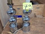 une table sur laquelle sont posées trois lampes, avec une boîte remplie de boîtes derrière