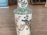 a vase with a bird on it sitting on a table