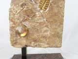 sculpture représentant une plume posée sur un rocher, reposant sur un socle en marbre