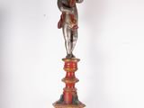a statue of a woman holding a candle on a pedestal