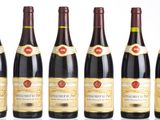 six bottles of wine are lined up in a row on a table