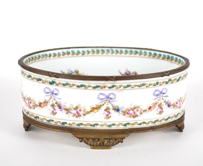 a white bowl with flowers on it on a stand