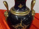 a blue and gold urn on an orange cloth