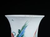 a white vase with colorful designs on it on a table