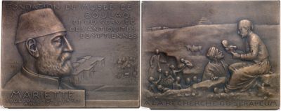 a close up of a metal plaque with a man and a dog